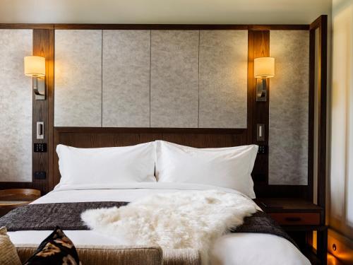 The Tasman, a Luxury Collection Hotel, Hobart في هوبارت: غرفة نوم مع سرير أبيض مع اللوح الأمامي كبير