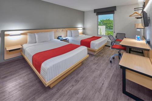 a hotel room with two beds and a desk at City Express by Marriott Irapuato in Irapuato