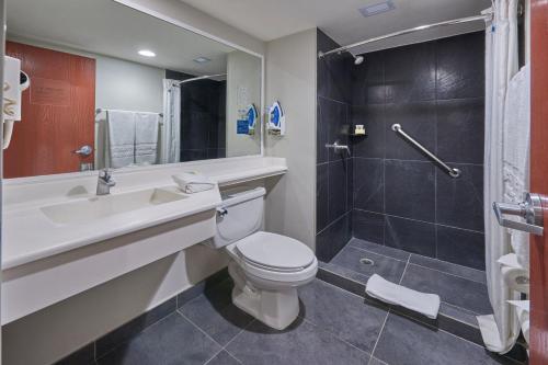 a bathroom with a toilet and a sink and a shower at City Express by Marriott Irapuato in Irapuato