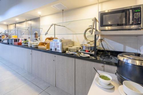 a kitchen with a counter with a microwave at City Express Junior by Marriott Bogota Aeropuerto in Bogotá
