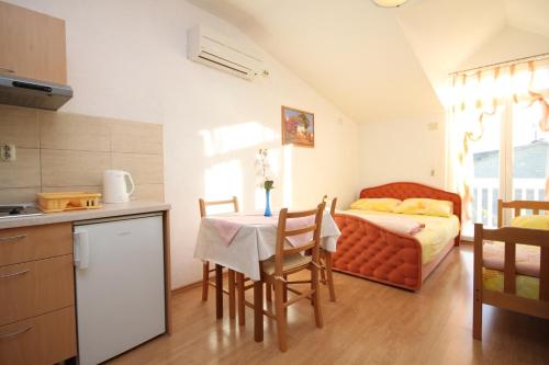 a kitchen with a table and a bed in a room at Apartments by the sea Kastel Kambelovac, Kastela - 8627 in Kaštela