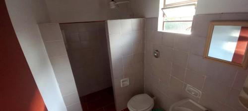 a bathroom with a shower with a toilet and a window at Casa do Maurição Refúgio da Família in Casimiro de Abreu