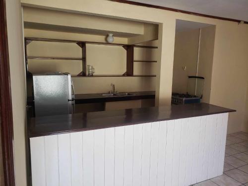 a kitchen with a counter with a sink and a mirror at Sunrise Hotel in Corn Island