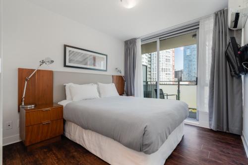 a bedroom with a large bed and a large window at Level Vancouver Yaletown Seymour in Vancouver