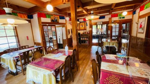 ペンションminiモンゴル في Makito: مطعم فيه طاولات وكراسي في الغرفة
