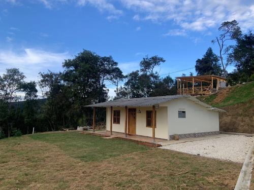una pequeña casa blanca en la cima de una colina en Guayacan Alojamiento, en Santa Elena