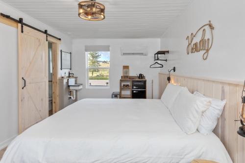 una camera da letto con un grande letto bianco e una finestra di Hotel Palomino a Ridgway