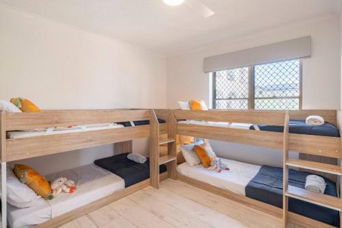 a room with three bunk beds in it at Kalua Holiday Apartments in Maroochydore
