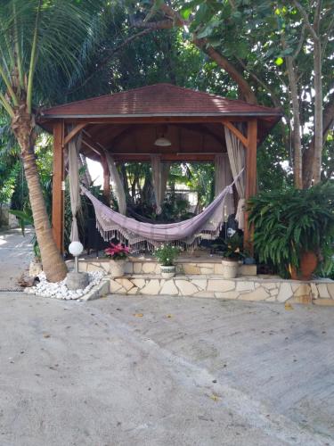 um gazebo de madeira com uma rede de descanso em Kote mer em Sainte-Anne