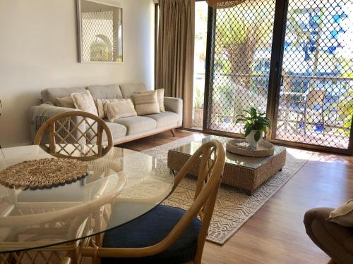 a living room with a glass table and a couch at Kalua Holiday Apartments in Maroochydore