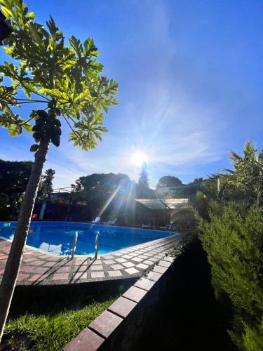 Papagalleros的住宿－Natural Luxury Hotel，享有游泳池的景色,阳光在天空中