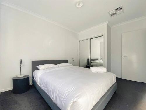 um quarto branco com uma cama grande e um espelho em Modern retreat. Pets welcome em Moama
