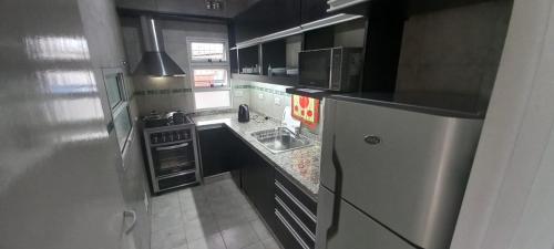 een kleine keuken met een koelkast en een wastafel bij FORMOSA RELAX in Formosa