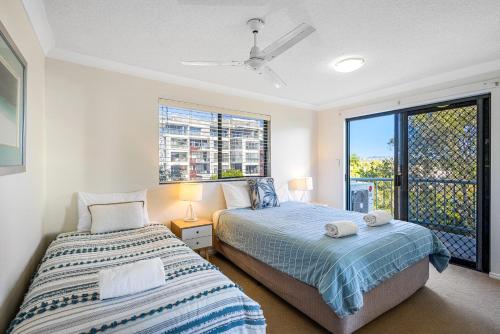 a bedroom with two beds and a window at Salty Kisses @ Riverdance - 3 bedroom apartment in Mooloolaba