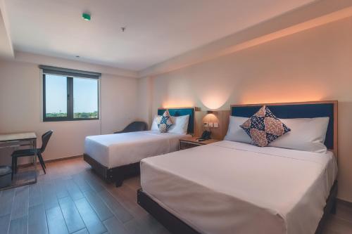 a hotel room with two beds and a desk at Lyz Business Hotel Piura in Piura