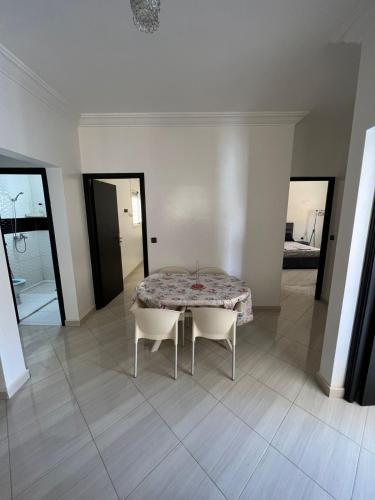 a dining room with a table and two chairs at Résidence Talhaoui in Saidia 