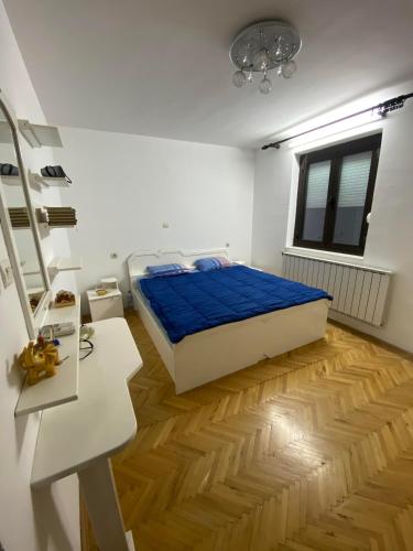 a bedroom with a bed and a wooden floor at Villa Magnifica in Strumica