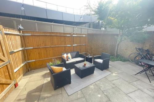 a patio with chairs and a table and a fence at Contemporary 1BD Flat wGarden - Whitechapel in London