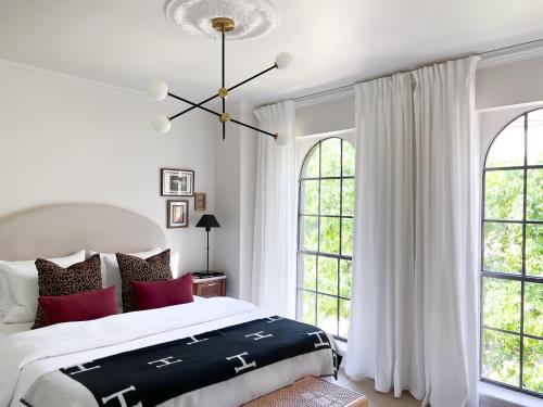 a white bedroom with a large bed with red pillows at MrNomad Boutique Hotel Parisian Townhouse in Dallas