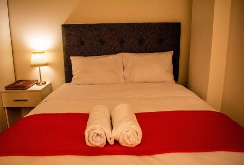 a bedroom with a bed with two towels on it at Miski Wasi in Cusco