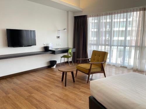 a hotel room with a bed and a desk and a television at Win Hotel in Sibu