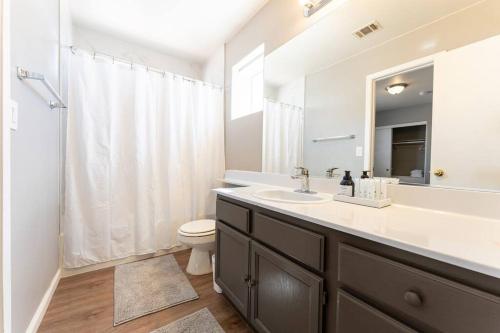 een badkamer met een wastafel, een toilet en een spiegel bij Work Friendly Fast Wi-Fi Convenient Location in Las Vegas