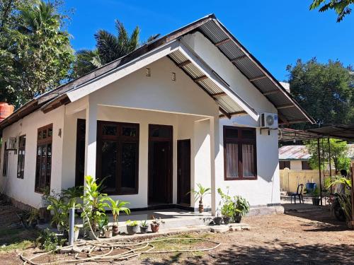 mały biały dom z roślinami przed nim w obiekcie Riung Tiga Empat Tujuh Guesthouse w mieście Riung