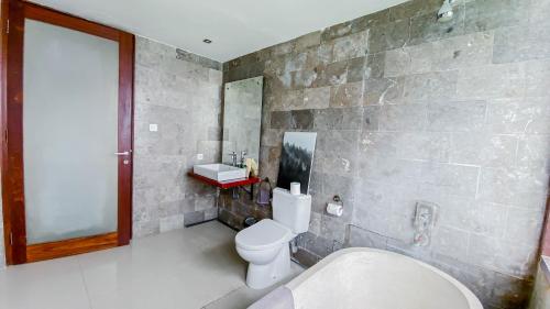 ein Badezimmer mit Toilette, Waschbecken und Badewanne in der Unterkunft Casa Naima Petitenget Villa in Seminyak