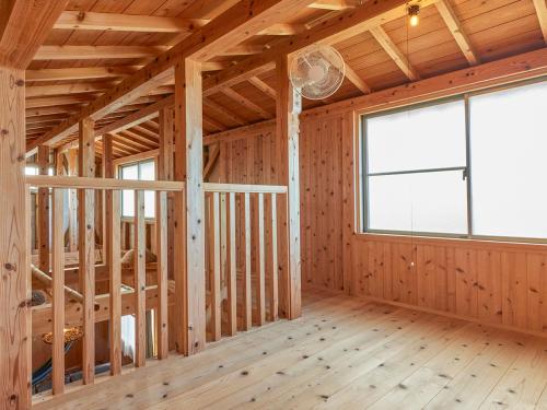 a room in a house under construction with a large window at Pension Snadun in Ginoza