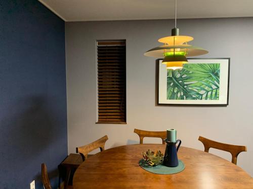 a dining room table with chairs and a vase on it at Hyeopjae MoonBeam in Jeju
