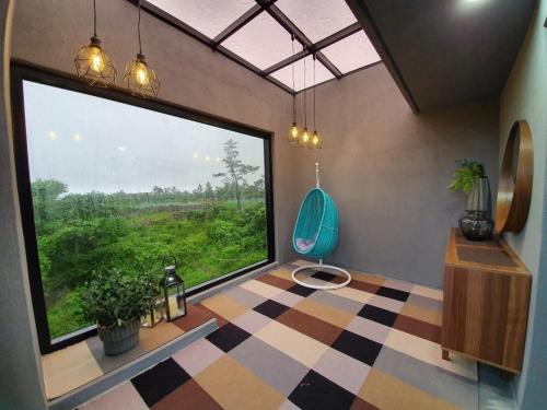 a room with a large window and a blue chair at Hyeopjae MoonBeam in Jeju
