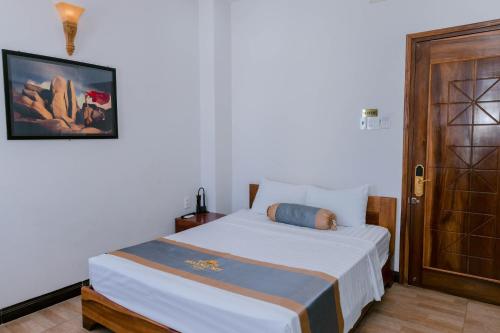 a bedroom with a bed and a wooden door at Khách sạn Hoàng My in Tuy Hoa