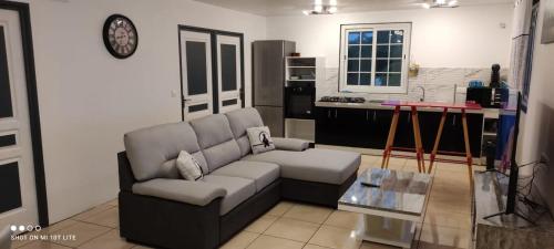 ein Wohnzimmer mit Couch und Küche in der Unterkunft Jimmyloc in Le Lamentin