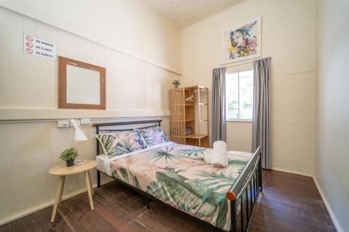 a small bedroom with a bed and a window at Halse Lodge Noosa Heads in Noosa Heads