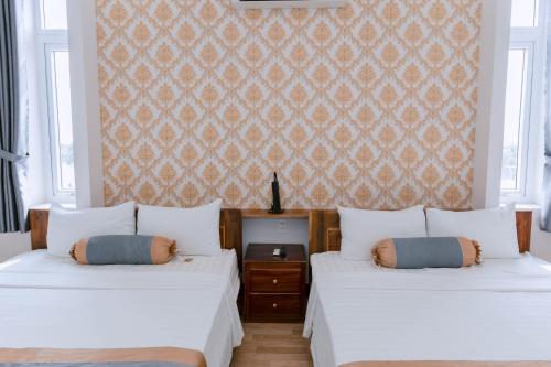 two beds sitting next to each other in a bedroom at Khách sạn Hoàng My in Tuy Hoa