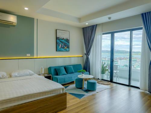a bedroom with a bed and a blue couch at Grand Hyams Hotel - TMS Tầng 21 View Biển Quy Nhơn - 2PN in Quy Nhon