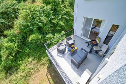 an overhead view of a balcony with chairs and tables at Suite Villa Izukogen Mikanno-Hanasaku-Shiroiie in Ito
