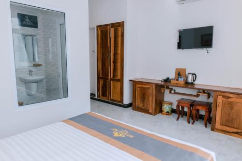 a bathroom with a sink and a desk and a tv at Khách sạn Hoàng My in Liên Trì (3)