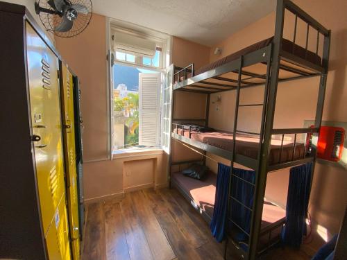 a room with two bunk beds and a window at Aurora Hostel Rio in Rio de Janeiro