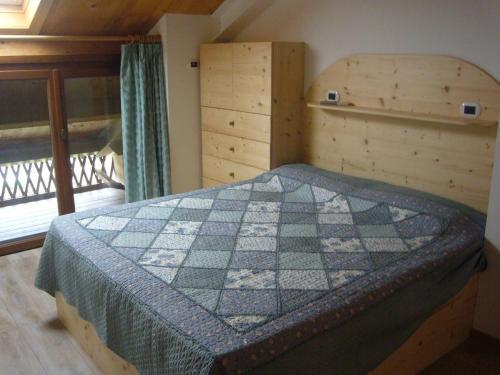 una camera con un letto con una trapunta sopra di Case Pizzocco a Santa Giustina a Meano