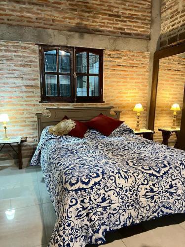 a bedroom with a blue and white bed and two windows at La Santa Rita Casa con Encanto! in San Fernando del Valle de Catamarca