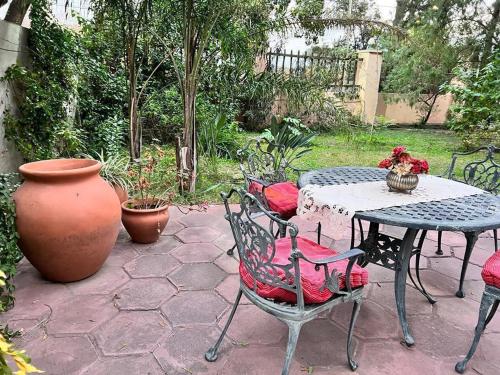 a patio with a table and chairs and a vase at La Santa Rita Casa con Encanto! in San Fernando del Valle de Catamarca