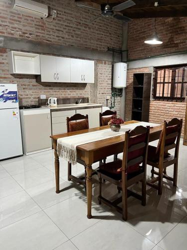 cocina con mesa, sillas y nevera en La Santa Rita Casa con Encanto! en San Fernando del Valle de Catamarca