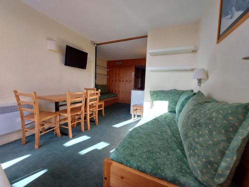 une chambre avec une table et un canapé ainsi qu'une salle à manger dans l'établissement Studio 4 pers, Arc 1800, skis aux pieds, proche commerces, animaux admis - FR-1-411-800, à Arc 1800