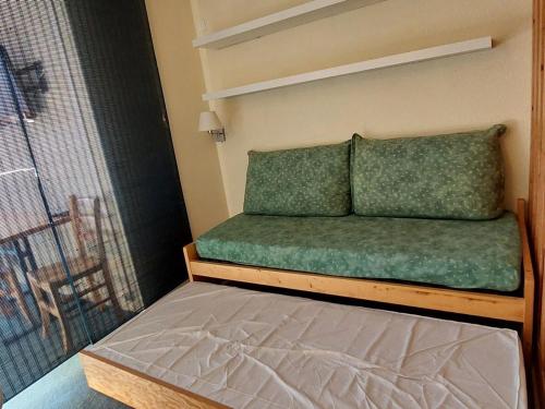 - un lit avec des draps et des oreillers verts dans l'établissement Studio 4 pers, Arc 1800, skis aux pieds, proche commerces, animaux admis - FR-1-411-800, à Arc 1800