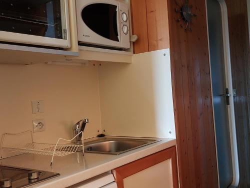 une cuisine avec un évier et un micro-ondes dans l'établissement Studio 4 pers, Arc 1800, skis aux pieds, proche commerces, animaux admis - FR-1-411-800, à Arc 1800