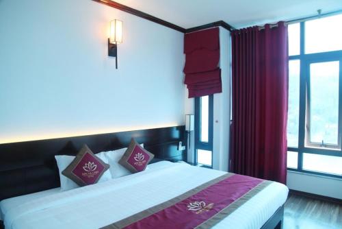 ein Schlafzimmer mit einem Bett und einem großen Fenster in der Unterkunft Sen Hotel Hạ Long in Hạ Long