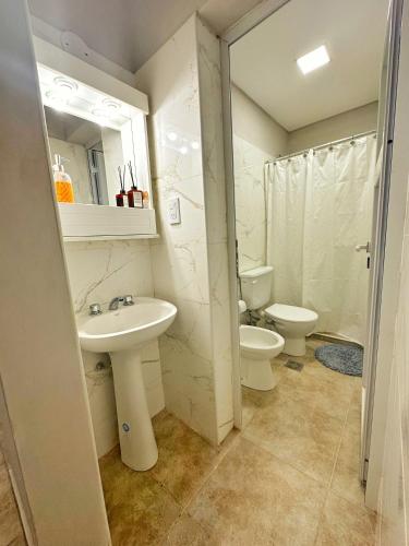 a bathroom with a sink and a toilet and a mirror at Paramont Rosario 1 in Rosario de la Frontera