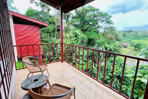 a balcony with two chairs and a table on it at Beautiful Casa Aire near Lake Arenal in Nuevo Arenal - Casas Airelibre in Nuevo Arenal