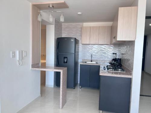 eine Küche mit einem schwarzen Kühlschrank im Zimmer in der Unterkunft Encanto urbano con la mejor vista y ubicación ! in Cúcuta